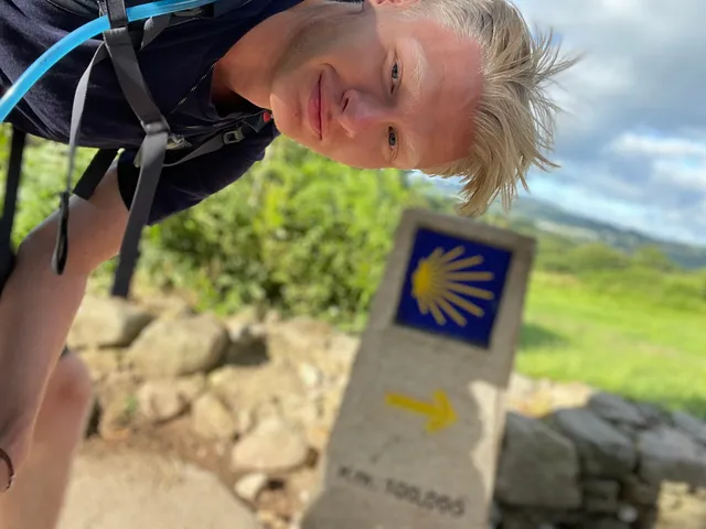 August on the Camino de Santiago, next to the 100 km marker with the yellow scallop shell